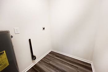 An empty room with a white wall and wooden floors